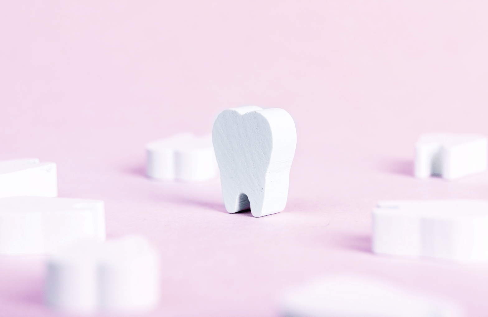 Erasers shaped like teeth on a pink backdrop.