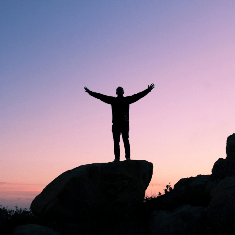 Man standing on rock with arms in arm.