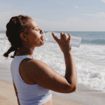 Woman drinking water on the beach
