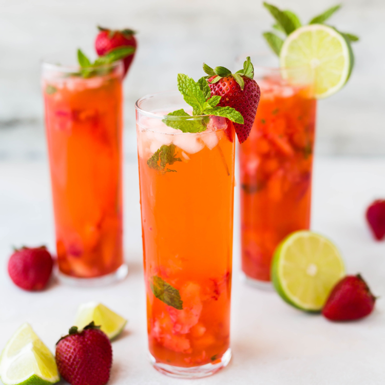Glasses of water infused with strawberries, limes and mint.