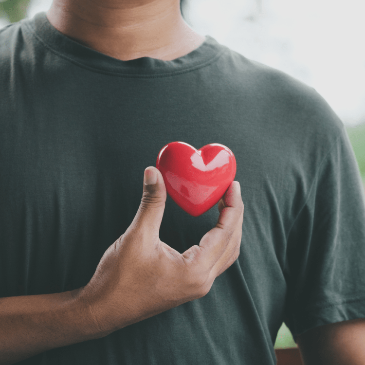 Man holding a red love-heart over his heart