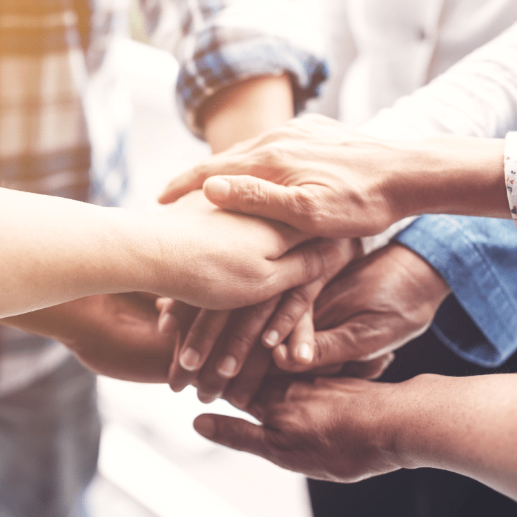 3 sets of hands being stacked together.