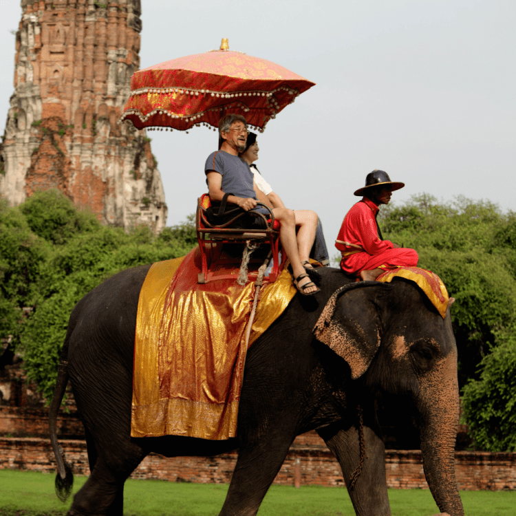 Two people riding an elephant.